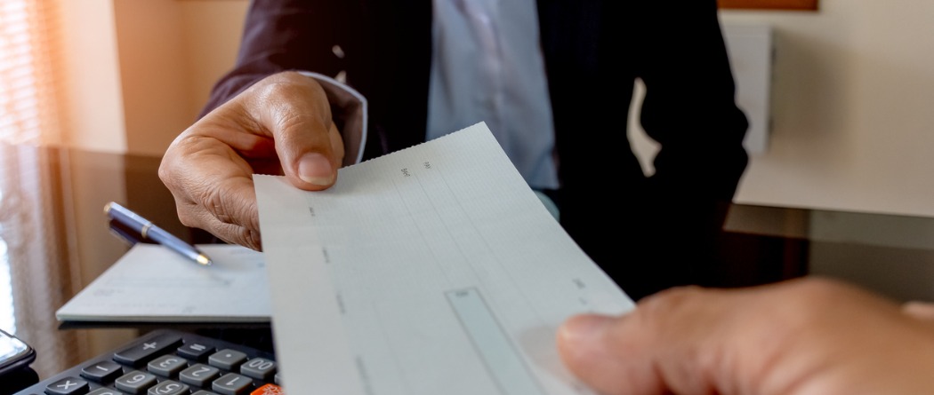 Person handing over a blank check
