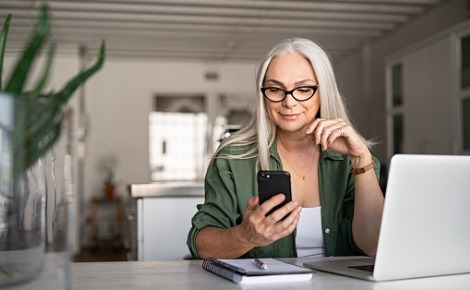 Woman looking at her phone in her home