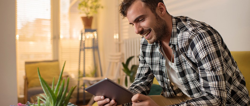 Farmer sitting on front porch using tablet