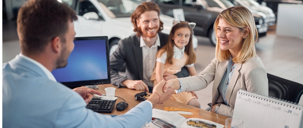 People at a dealership shaking hands