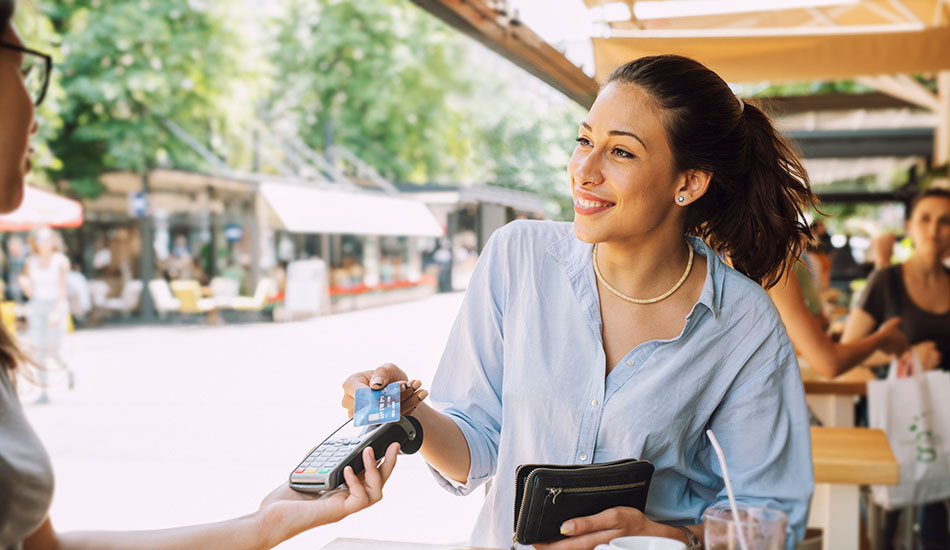 Woman paying with debit card at restaurant